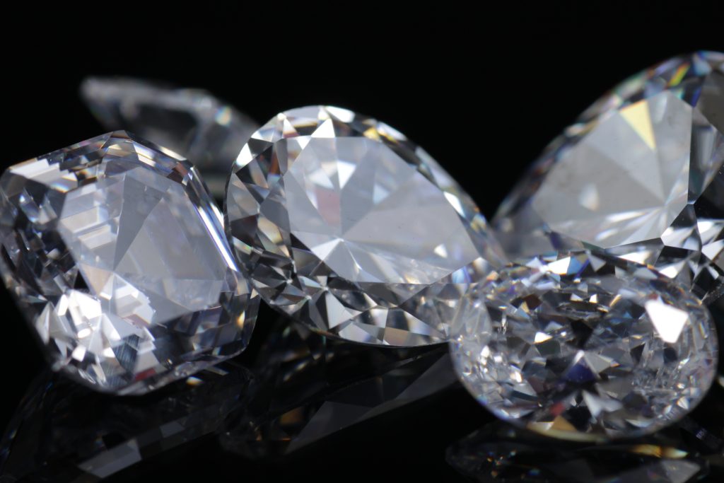 Macro shoots of a group of diamonds that has different shapes, heart, round, pear, asscher, oval, princess, isolated background